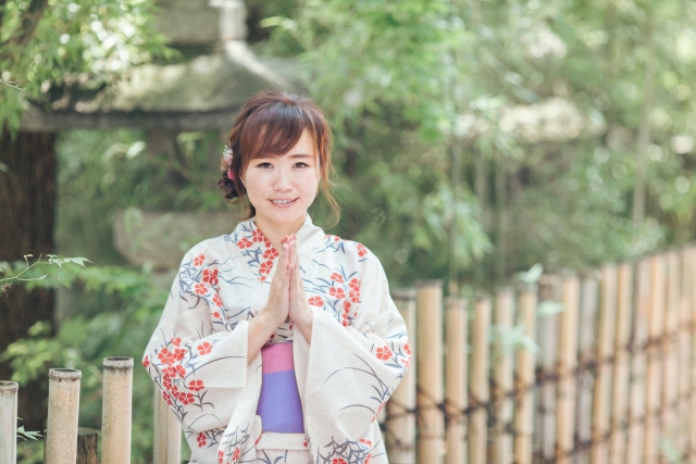浴衣で手を合わせる女性