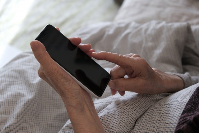 スマホを手にする高齢者